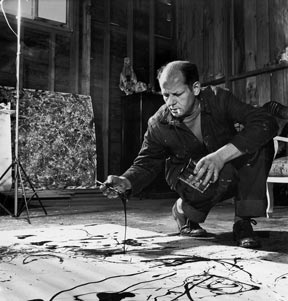 Artist Jackson Pollock dribbling sand on painting while working in his studio.